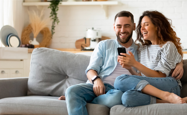 young couple laughing on couch