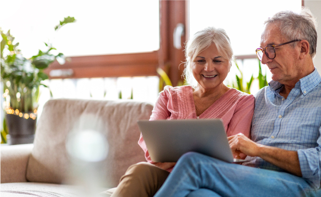 older couple on couch looking at laptop